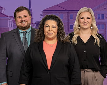 Three smiling members of the Financial Aid team. A man with short brown hair, a woman with curly brown hair, and a woman with wavy blonde hair.